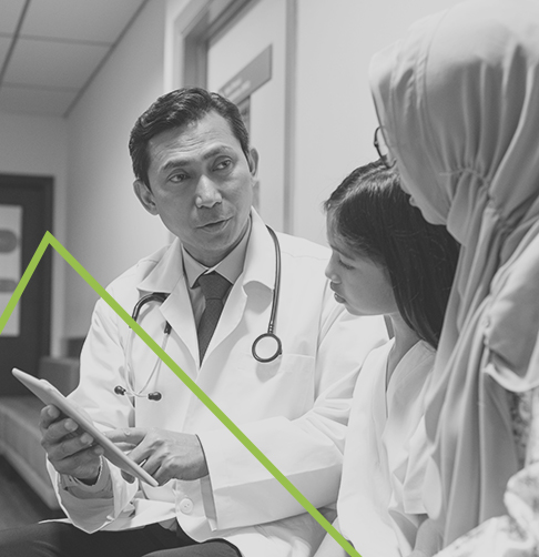 A doctor is speaking with a mother and her daughter.