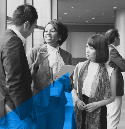 A small group of advisors talk casually in a large office space. 